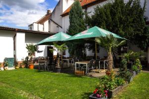 a patio with tables and chairs and umbrellas at Hotel Rychta Netolice in Netolice