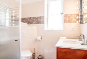 La salle de bains est pourvue d'un lavabo, de toilettes et d'un miroir. dans l'établissement Le Vieux Logis Chambres d'Hôtes, à La Farlède