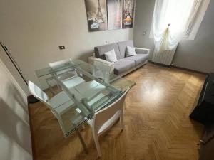 uma sala de estar com uma mesa de vidro e um sofá em Casa Casò Guest House em Bolonha