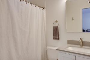a white bathroom with a shower curtain and a sink at Breezy Point Cabin Deck with Golf Course Views! in Pequot Lakes +22 photos
