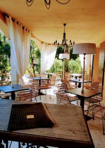 ein Restaurant mit Tischen, Stühlen und einem Kronleuchter in der Unterkunft Maison Prestige Saint Tropez by Roberto Geissini in Grimaud