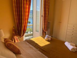 Schlafzimmer mit einem Bett und einem großen Fenster in der Unterkunft BELLE ILE LAKE VIEW SUITE in Griante Cadenabbia