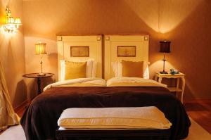 a large bed in a room with two lamps at Casas Do Coro in Marialva