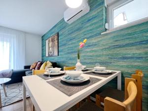 a dining room with a table with a flower on it at Apartments Valerian in Novigrad Istria