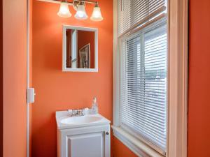 baño naranja con lavabo y ventana en Shamokin Bed and Breakfast, en Shamokin