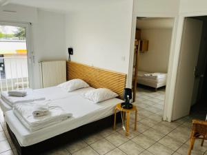 a bedroom with a large white bed in a room at HOSTEL Les Bois Verts - Les Herbiers in Les Herbiers