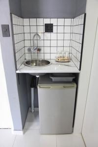 uma pequena cozinha com um lavatório e uma lata de lixo em 4447 Guesthouse em Pimville