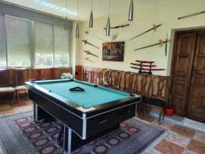 a pool table in a room with leather chairs at Casita de invitados cerca de Madrid in Moralzarzal