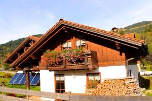 a house with a balcony with flowers on it at Landhaus Alpenstern in Unterjoch