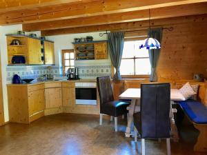 a kitchen with a table and chairs in a cabin at Landhaus Alpenstern 