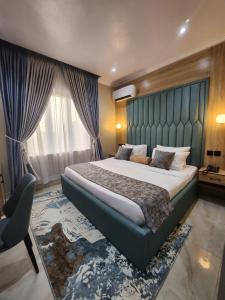 um quarto com uma cama grande e uma cabeceira azul em Atlantic Palms Suites em Lekki