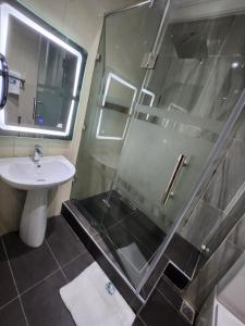uma casa de banho com um chuveiro e um lavatório. em Atlantic Palms Suites em Lekki