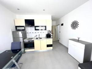 a white kitchen with a sink and a refrigerator at Apartman Solin 3, parking in Solin