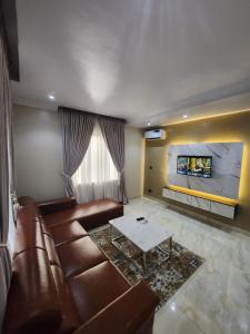 a living room with a brown leather couch and a fireplace at Atlantic Palms Suites in Lekki