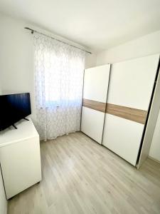 a room with two sliding doors and a television at Apartman Solin 3, parking in Solin