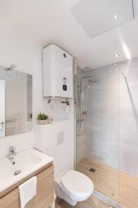 a white bathroom with a toilet and a shower at Le Bohémien - Résidence Hestia in Saint-Étienne
