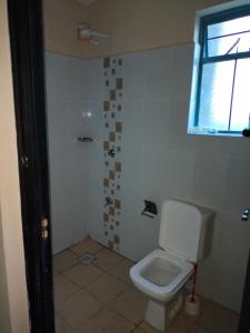 baño con aseo y ventana en Executive 1&2 Broom Airbnb in Gilgil Nakuru, en Gilgil