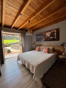 a bedroom with a large bed and a large window at Pico Formoso Vínea Lava Alojamentos Pico in Prainha de Baixo