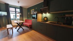 kuchnia ze stołem i czerwonym krzesłem w obiekcie Der grüne Fürst Ferienwohnung Appartement 1 w mieście Mużaków