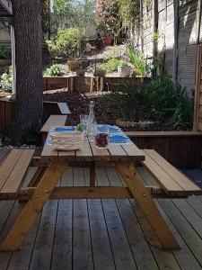 a wooden picnic table on a deck with a table at 3 pièces avec terrasse arborée in Arcachon
