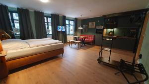 Der grüne Fürst Ferienwohnung Appartement 1 في باد موسكاو: غرفة نوم بسرير ومطبخ وطاولة