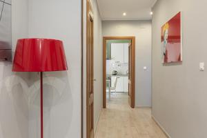 Habitación con lámpara roja y pasillo en Appartamento Dante en Novi Ligure