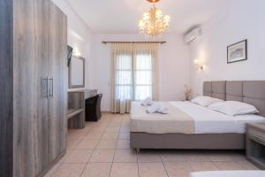 a bedroom with two beds and a sink and a mirror at Star Paradise Hotel in Neos Marmaras