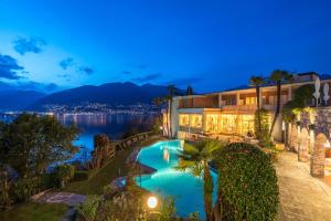a house with a swimming pool at night at Bellavista Swiss Quality Hotel in Vira