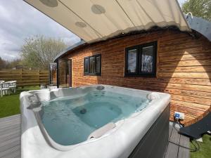 una bañera de hidromasaje en una terraza con una casa en Forbes of Kingennie en Dundee