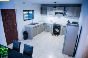 uma cozinha com um frigorífico e uma mesa com cadeiras em Blue Agave F2 em Lusaka
