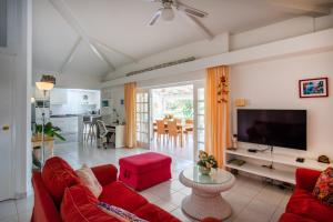 uma sala de estar com um sofá vermelho e uma televisão de ecrã plano em Piscadera Bay Resort 25 em Willemstad