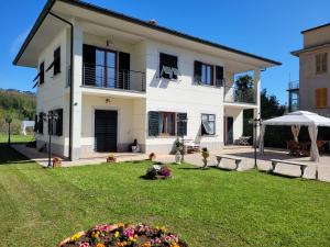 una gran casa blanca con un patio con flores en Appartamento in villa a 20 min da Levanto e dalle 5 Terre-Sesta Godano en Sesta Godano