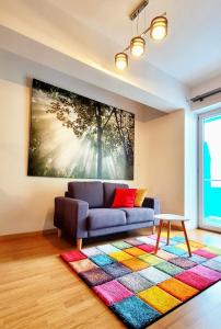 a living room with a couch and a painting on the wall at Cosy one bedroom apartment, close to Iulius Mall in Cluj-Napoca