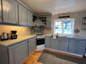 a kitchen with white cabinets and a sink at Trollstigen Resort in Åndalsnes