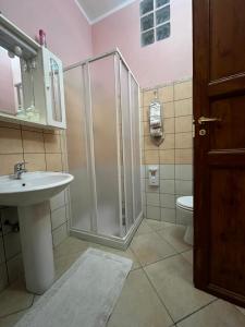 een badkamer met een douche, een wastafel en een toilet bij B&B Su Maimoni in Iglesias