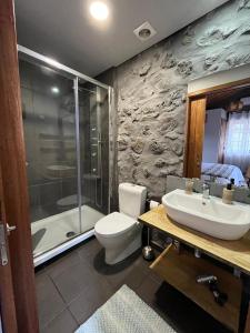 uma casa de banho com um WC, um lavatório e um chuveiro em Pico Formoso Vínea Lava Alojamentos Pico em Prainha de Baixo