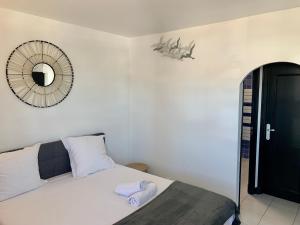 Schlafzimmer mit einem Bett und einem Wandspiegel in der Unterkunft MarinesAppartement-Yachts view, 100m Beach, Fiber Wifi High speed in Saint-Tropez