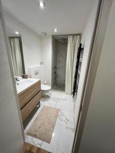 une salle de bains avec lavabo, toilettes et douche dans l'établissement Résidence de l'Ariondaz - Courchevel, à Courchevel