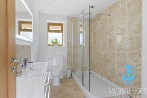 a bathroom with a shower and a toilet and a sink at Boundary Cottage - Spacious Homely Cottage With Log Burner and Garden in Marldon