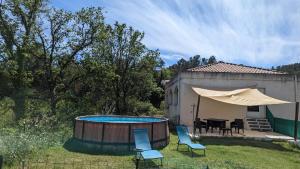 a backyard with a hot tub and chairs and a table at Maison Pré Long et Pré Long House in Le Thoronet