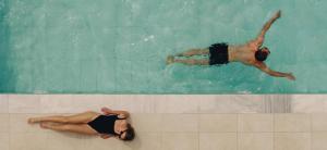 um homem e uma mulher a nadar numa piscina em Regency Boutique Hotel Holiday Suites em Pafos