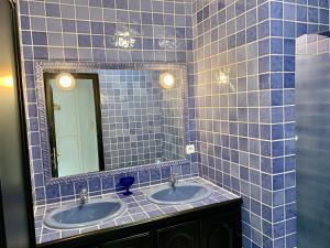 ein blau gefliestes Bad mit 2 Waschbecken und einem Spiegel in der Unterkunft MarinesAppartement-Yachts view, 100m Beach, Fiber Wifi High speed in Saint-Tropez