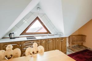 eine Küche mit einem Tisch und einem Fenster in der Unterkunft Dworek na Wzgórzu in Rzepiska + 15 Fotos
