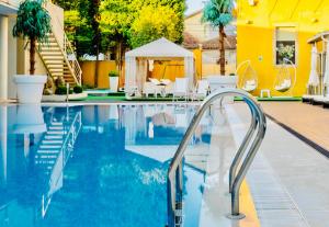 a swimming pool with a stairway leading to a yellow house at Plaza House Ílhavo in Ílhavo