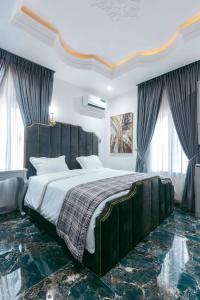 a bedroom with a large bed with a wooden headboard at Phoenix Luxury Apartments in Abuja