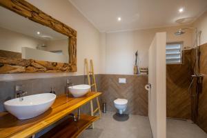 ein Badezimmer mit zwei Waschbecken und einem WC in der Unterkunft PUUR! appartementen Curaçao in Jan Thiel