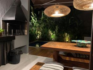 a dining room with a table and plants at Casa com serviço de praia e piscina privativa, Juquehy! in Juquei