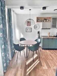 a kitchen and dining room with a table and chairs at Home Apartment LUNA in Skopje