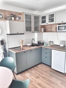 a kitchen with white and blue cabinets and a table at Home Apartment LUNA in Skopje