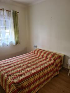 una camera con un letto con una coperta a righe di Casa 28 a Pataias